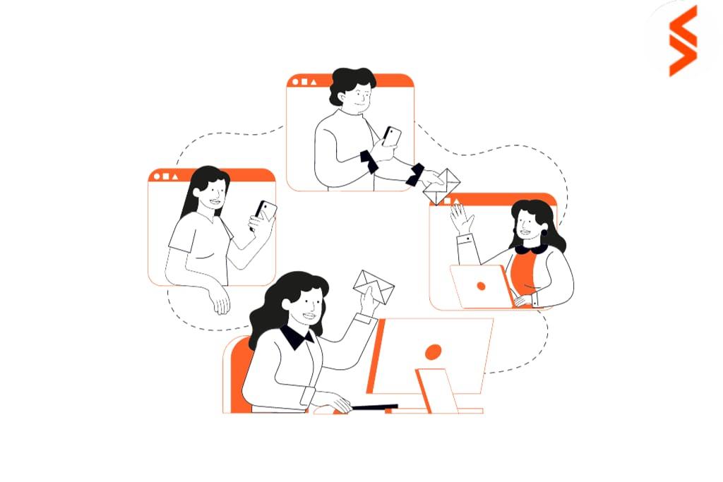 A diverse group of individuals focused on their laptops, collaborating in a modern workspace environment.